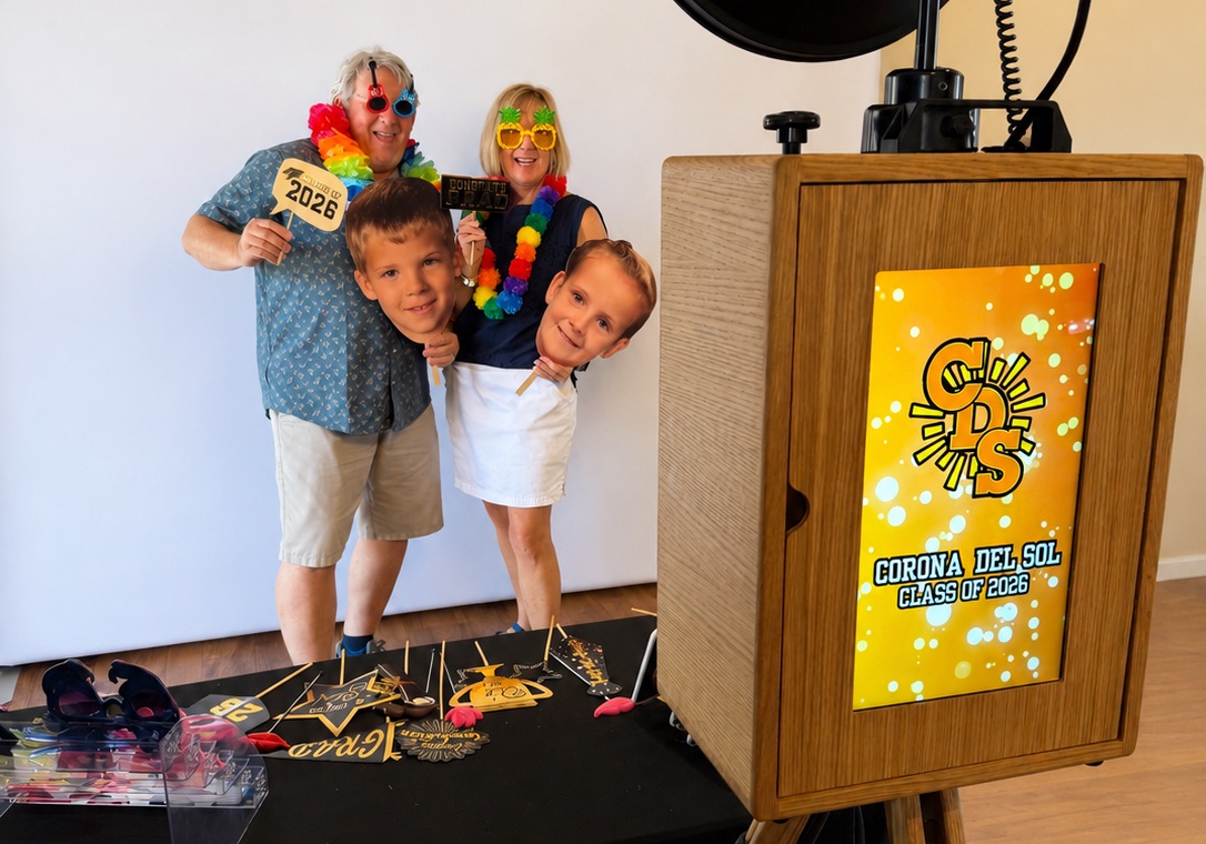 A family celebrating with graduation props at a Class of 2026 photo booth event