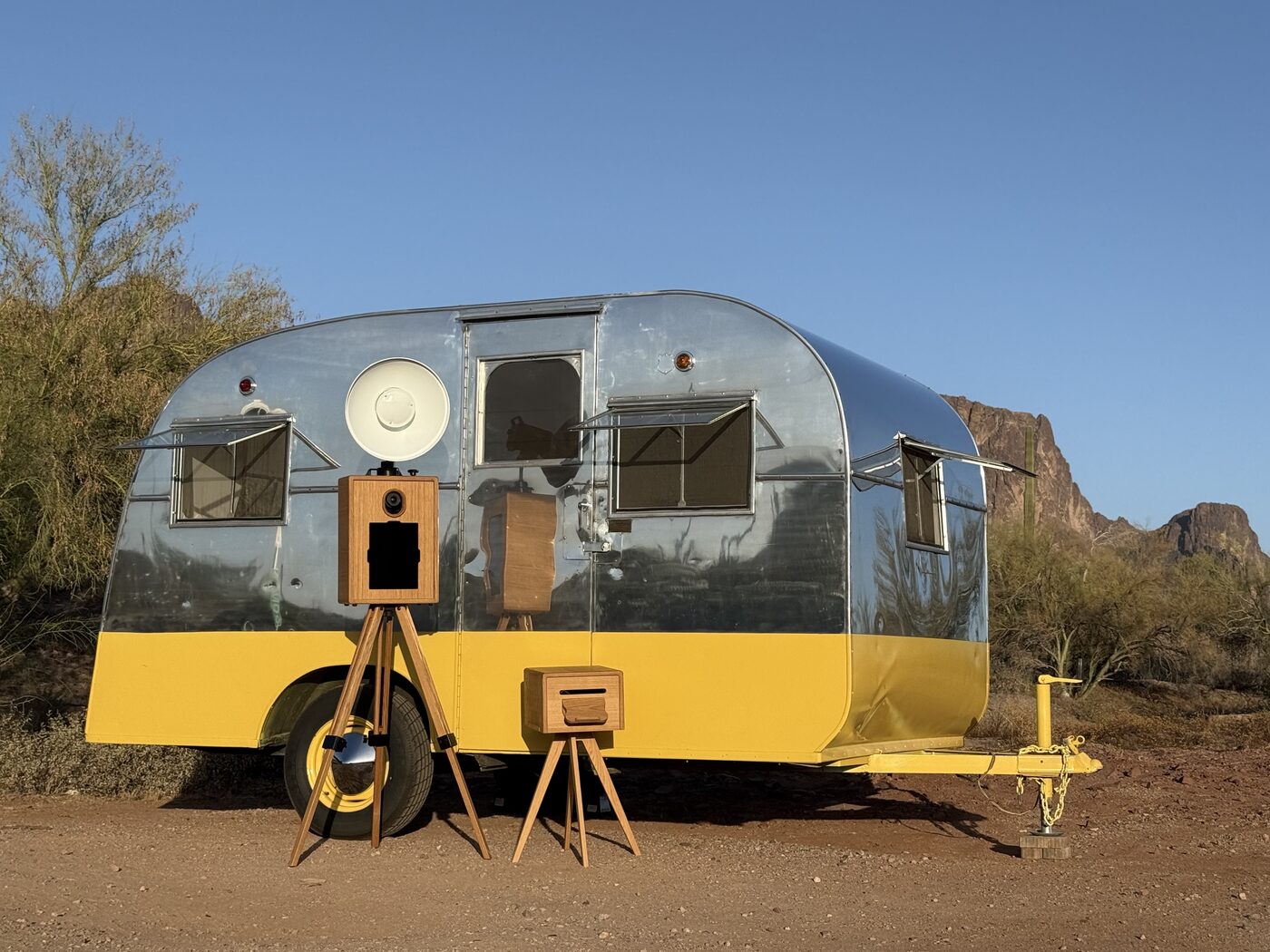The open-air photo booth set up in front of the vintage trailer in the Arizona desert